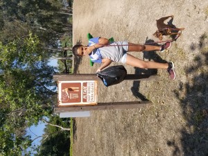 Standing next to one of many trash cans for the public to use..