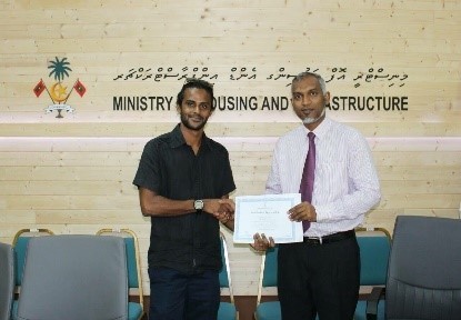 Minister of Housing and Infrastructure awards certificate of appreciation.