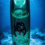 I will take a picture of the abandoned glass bottle in the sea.